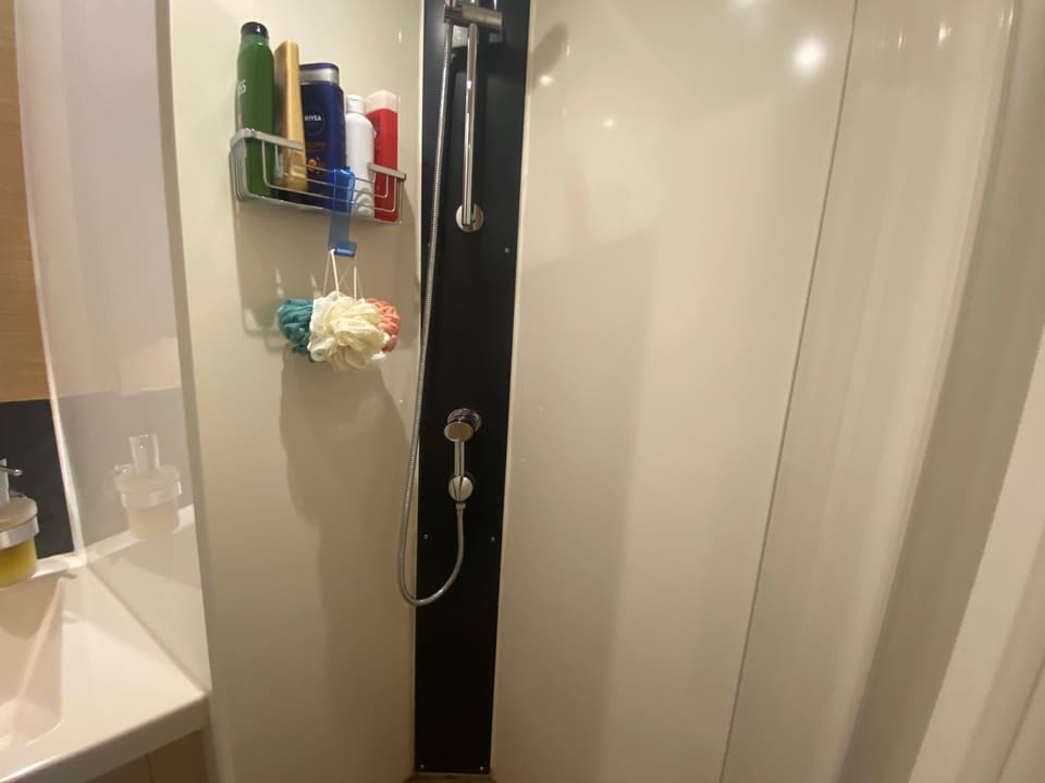 2018 Hanse 548 – shower stall with hand shower on a dark rail, cream wall panels and toiletry rack