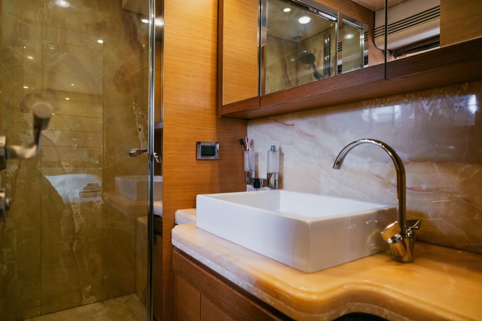 2007 Custom Line 97 – oniks lavabo tezgahı, beyaz çanak lavabo, mermer duvarlar ve cam duşakabinli banyo