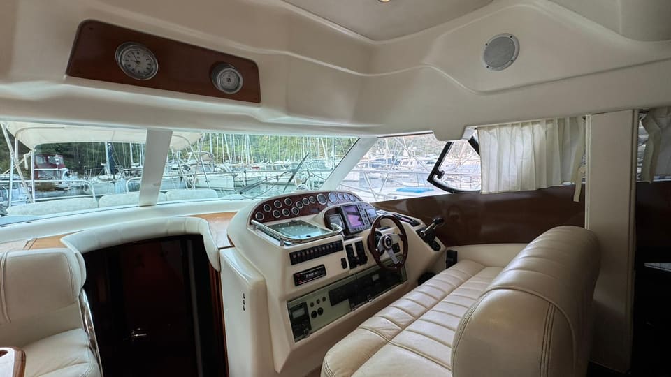 2002 Prestige 46 – interior lower helm station with navigation displays, cream leather seating and panoramic windows