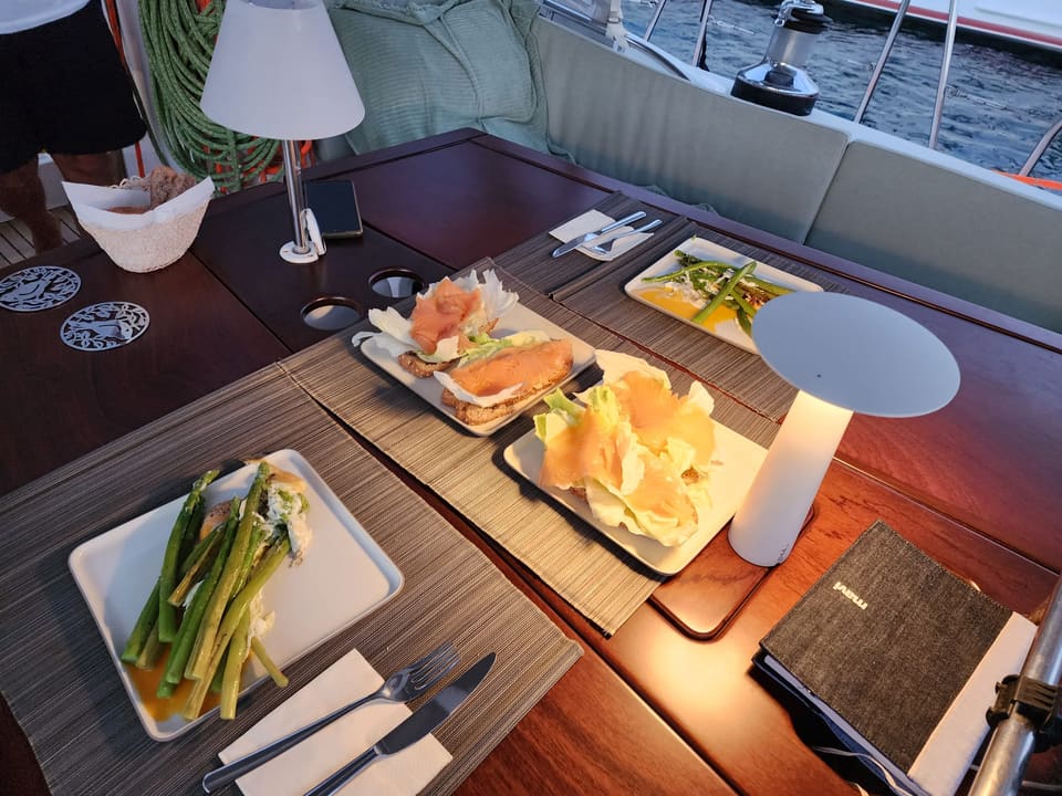 2009 Beneteau Oceanis 54 – kokpitte servis tabakları, şarjlı lambalar ve minderli oturma alanıyla hazırlanmış yemek masası