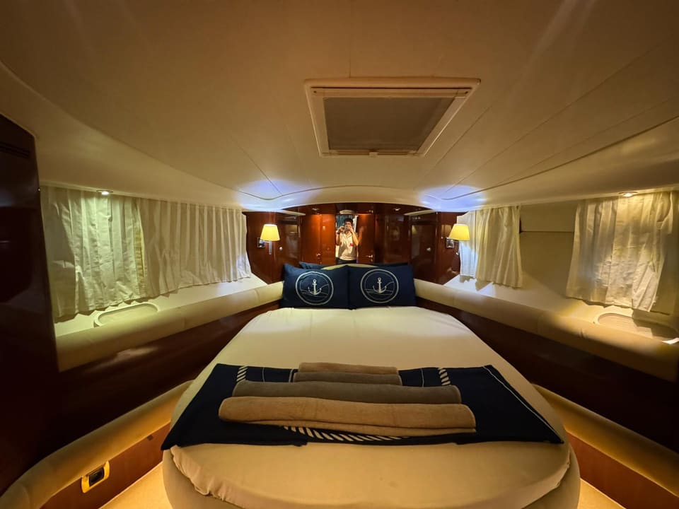 2002 Prestige 46 – forward cabin with island double bed, anchor-motif cushions, cherry wood joinery and curtained windows