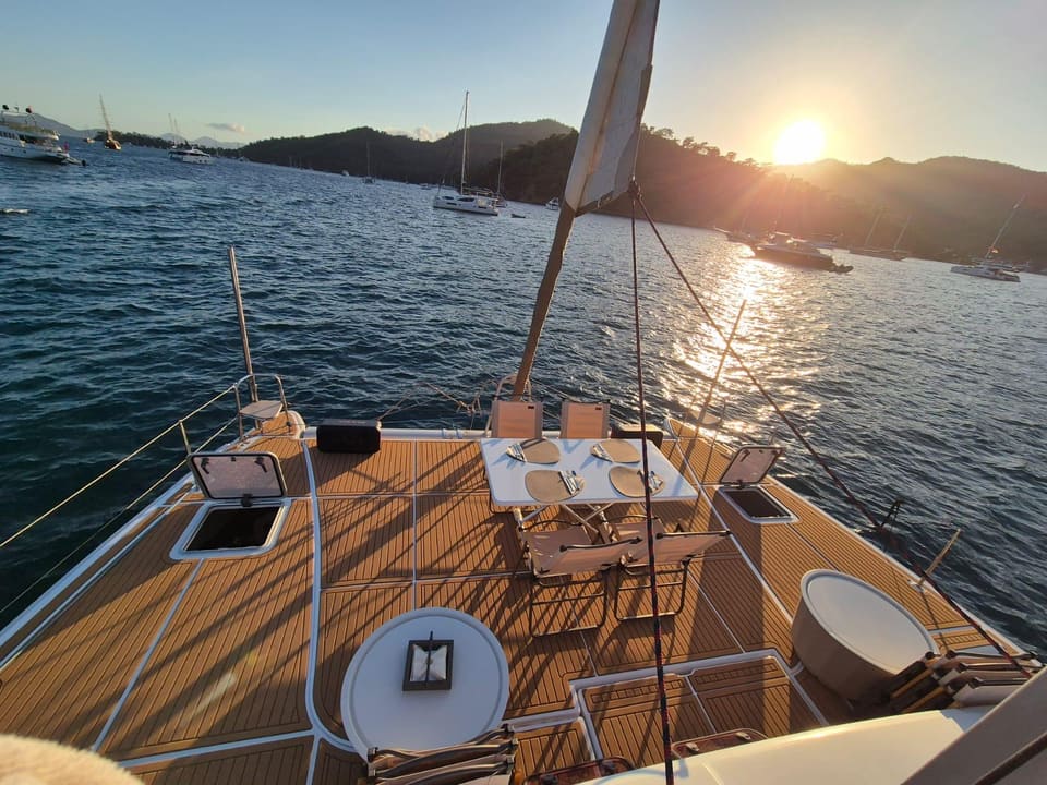 2010 Lagoon 400 – foredeck with teak-style decking, dining table set for guests and sunset sea view