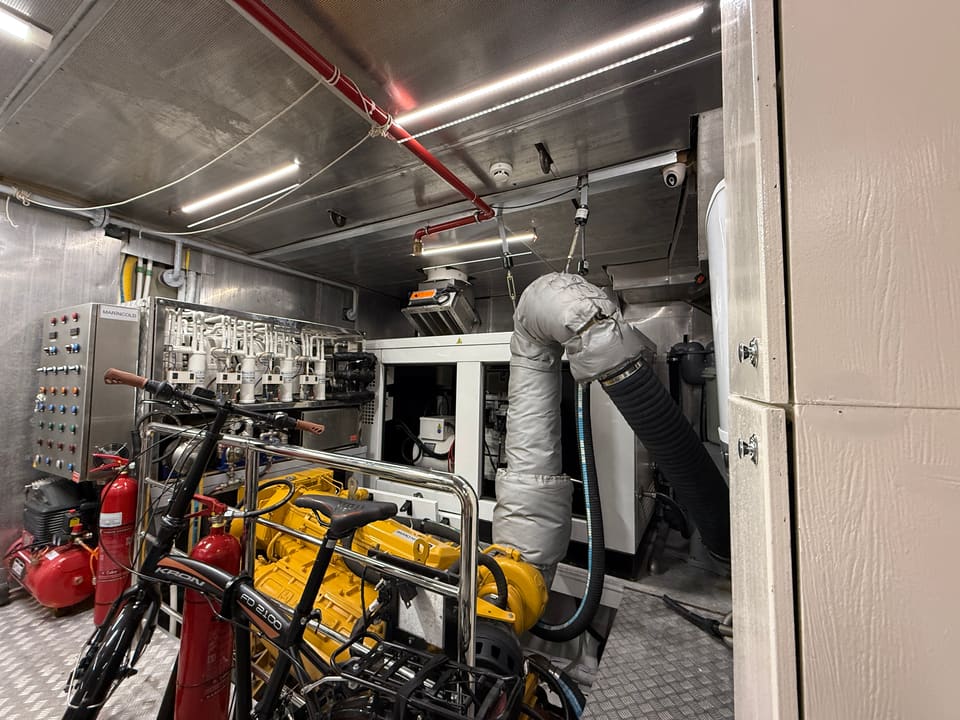 2023 Custom Laminated Motorsailer 41M – engine room with yellow engine, insulated exhaust, generator and control panel