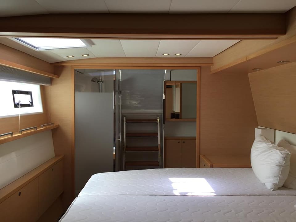 2015 Lagoon 560 S2 – çift kişilik yataklı, borda pencereli ve tavan lumbozlu ana kabin; banyo ve merdiven görünümü