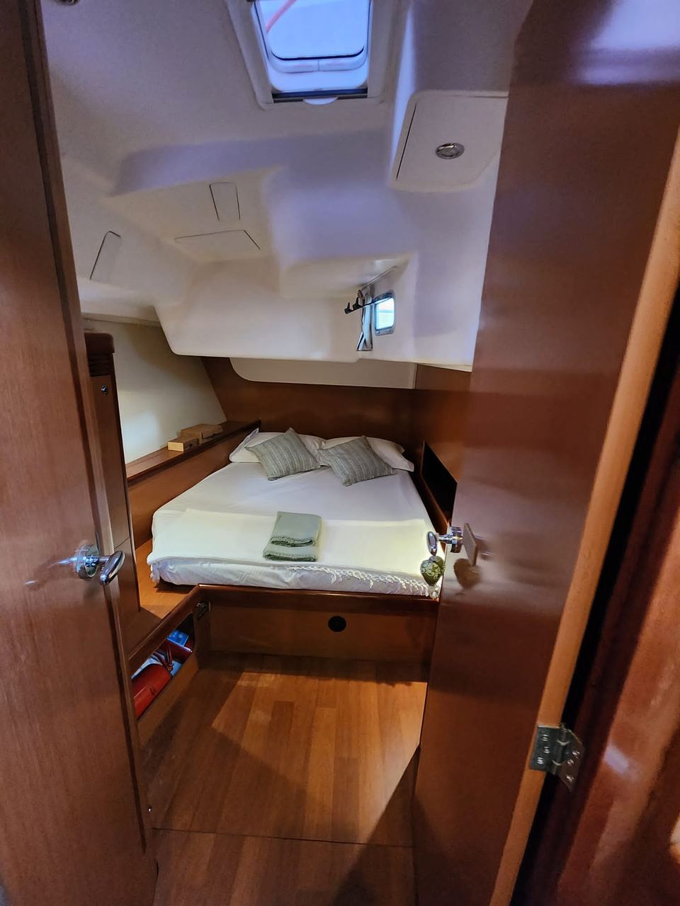 2009 Beneteau Oceanis 54 – çift kişilik yataklı misafir kabini, sıcak ahşap işçiliği, tavan kapağı ve tik görünümlü zemin