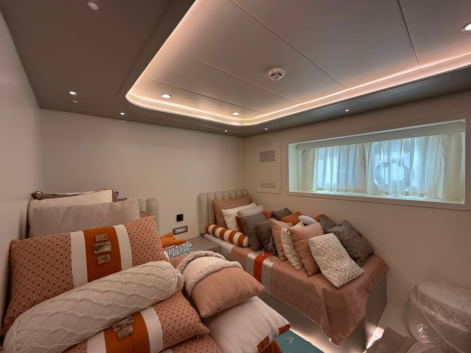 2023 Custom Laminated Motorsailer 41M – guest cabin with two single beds, orange-accented cushions and cove-lit ceiling