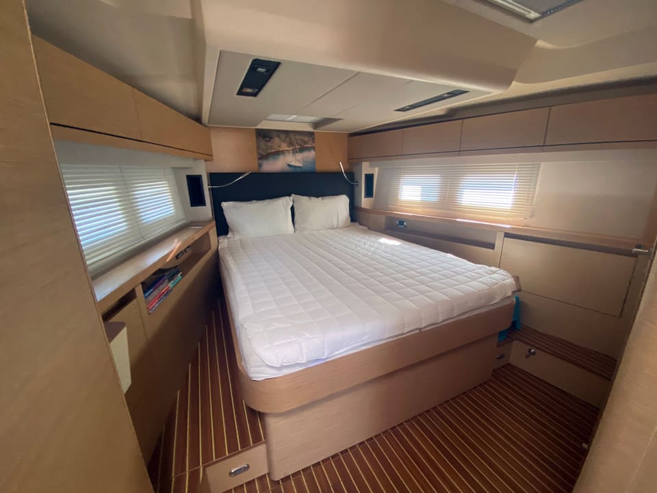 2018 Hanse 548 – master cabin with double bed, light oak joinery, teak-style floor and hull windows