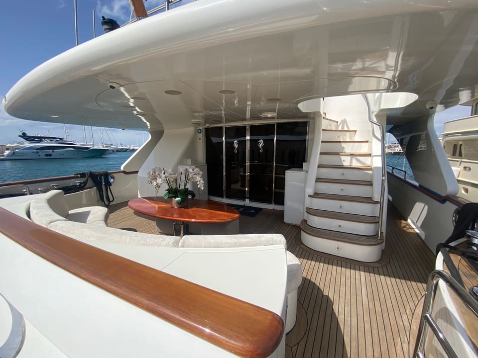 2003 Benetti Classic 115 – aft deck with curved sofa, teak table, teak decking and stairs to the upper deck