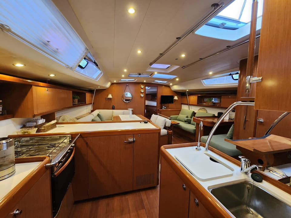 2009 Beneteau Oceanis 54 – ocak, çift eviye ve tik dolaplarla donatılmış, salona açılan mutfak