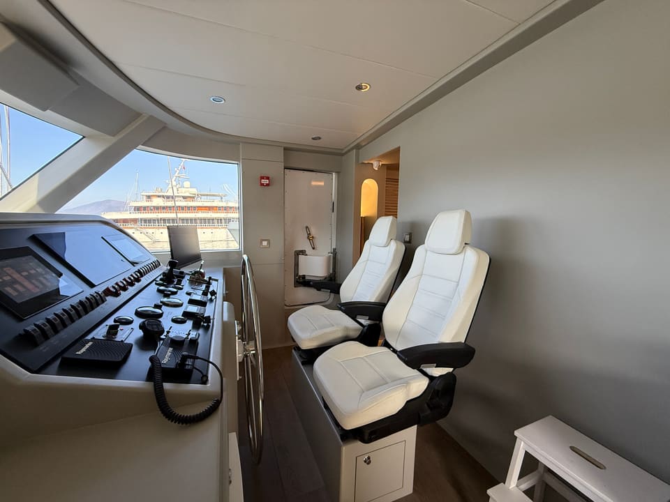 2023 Custom Laminated Motorsailer 41M – wheelhouse with white leather helm chairs, navigation console and wide forward windows