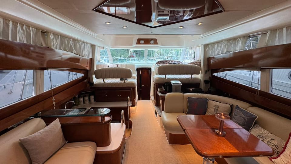 2002 Prestige 46 – saloon with cream sofas, cherry wood joinery, dining table and lower helm forward