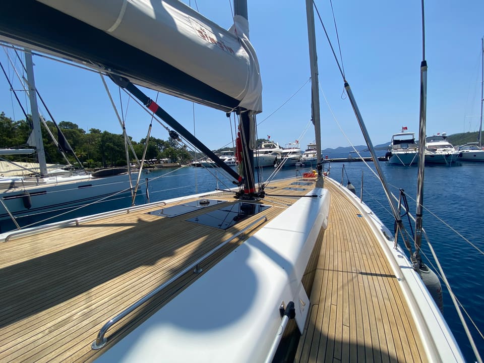 2018 Hanse 548 – teak side deck and foredeck with flush hatches, furled mainsail on boom and stainless handrails