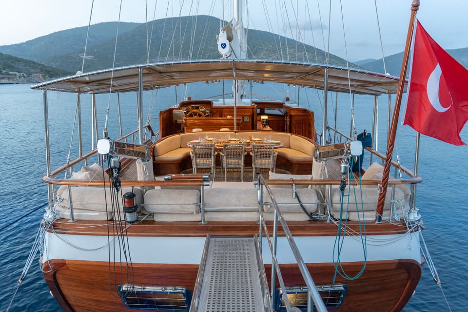 2009 Custom Ketch 31M – aft deck with passerelle, shaded dining table, lounge sofas and sun pads at dusk