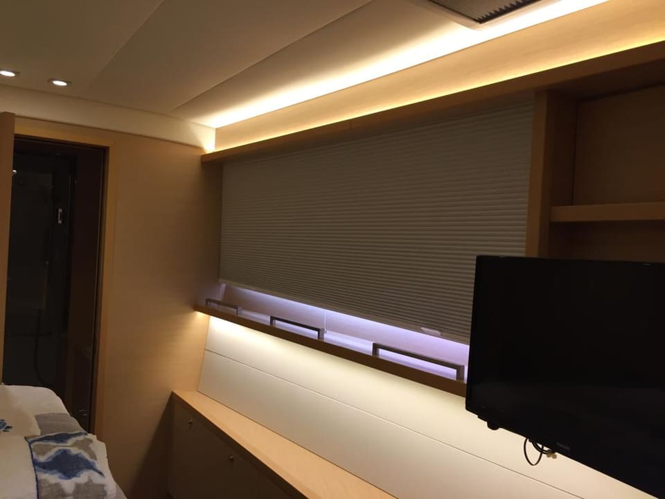 2015 Lagoon 560 S2 – plise perdeli, ambiyans LED aydınlatmalı, duvara monte TV'li ve açık renk ahşap işçilikli kabin