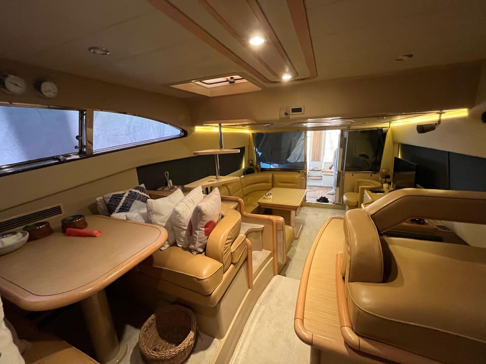 2005 Ferretti 530 – saloon with beige leather seating, dining table, helm seat and aft deck access