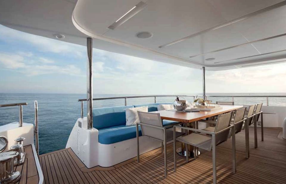 2016 Benetti Tradition Supreme 108 – tik zeminli kapalı kıç güverte, açık hava yemek masası ve deniz manzaralı mavi kanepe