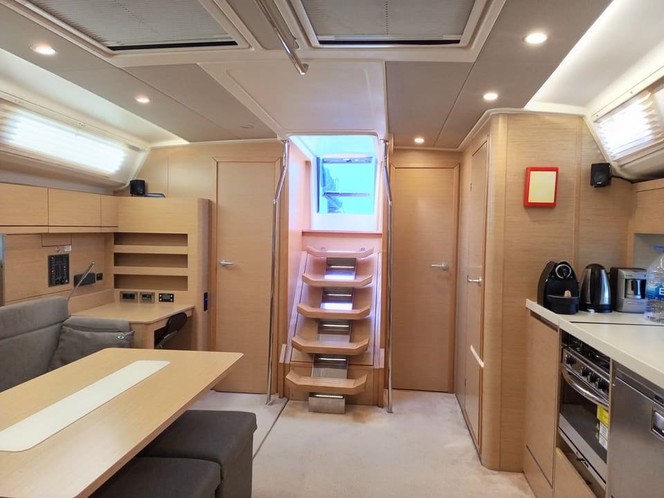 2022 Hanse 508 – yemek masası, mutfak, giriş merdiveni ve tavan kaportalarıyla salon
