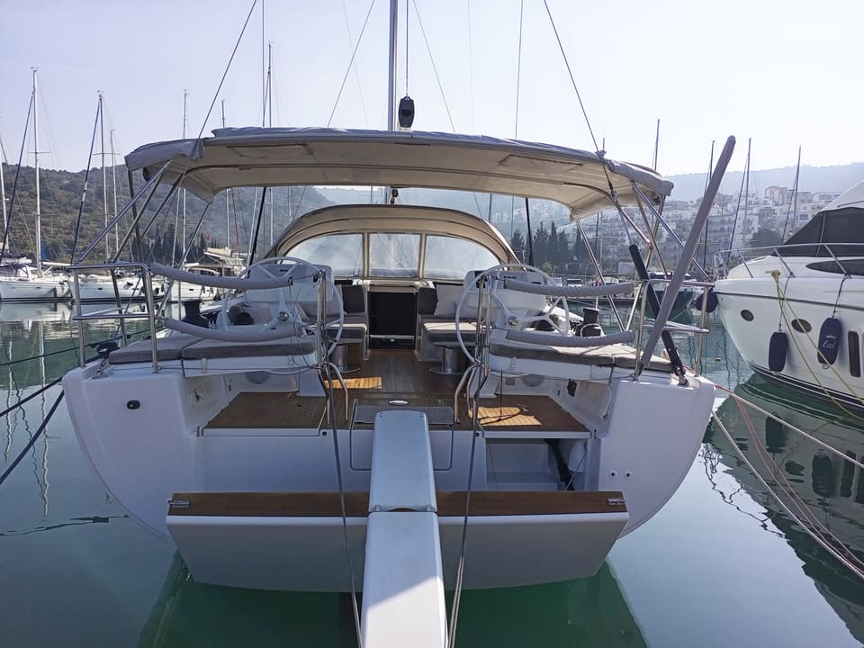 2022 Hanse 508 – stern view of cockpit with twin helms, teak decking, bimini and fold-down swim platform