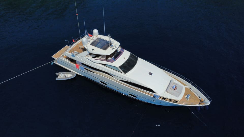 2007 Custom Line 97 – demirdeki motoryatın havadan görünümü, flybridge, baş güverte güneşlenme minderleri ve yanında tender