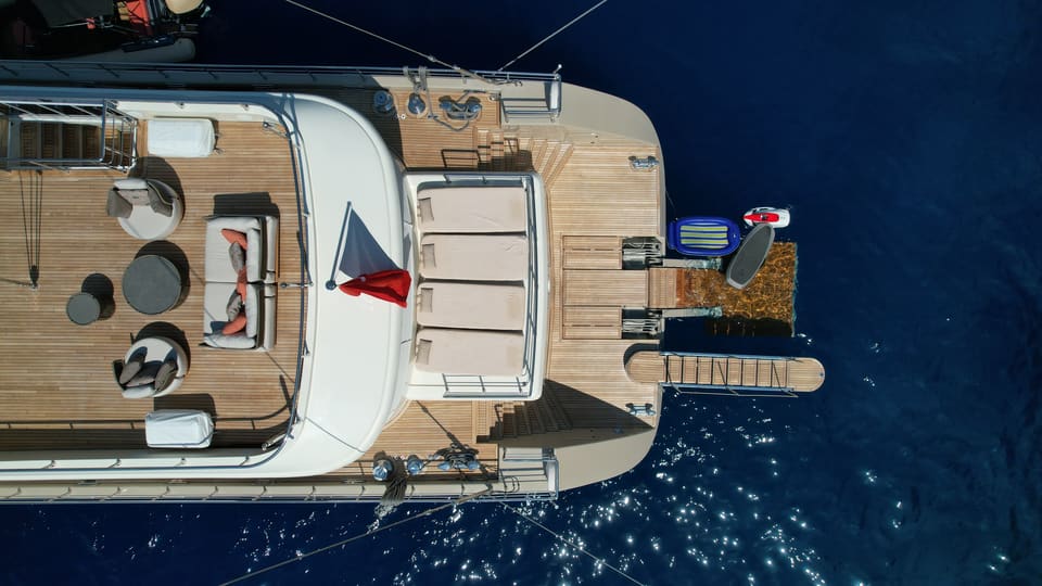 2023 Custom Laminated Motorsailer 41M – aerial view of teak aft deck with sun pads, lounge seating and swim platform with water toys