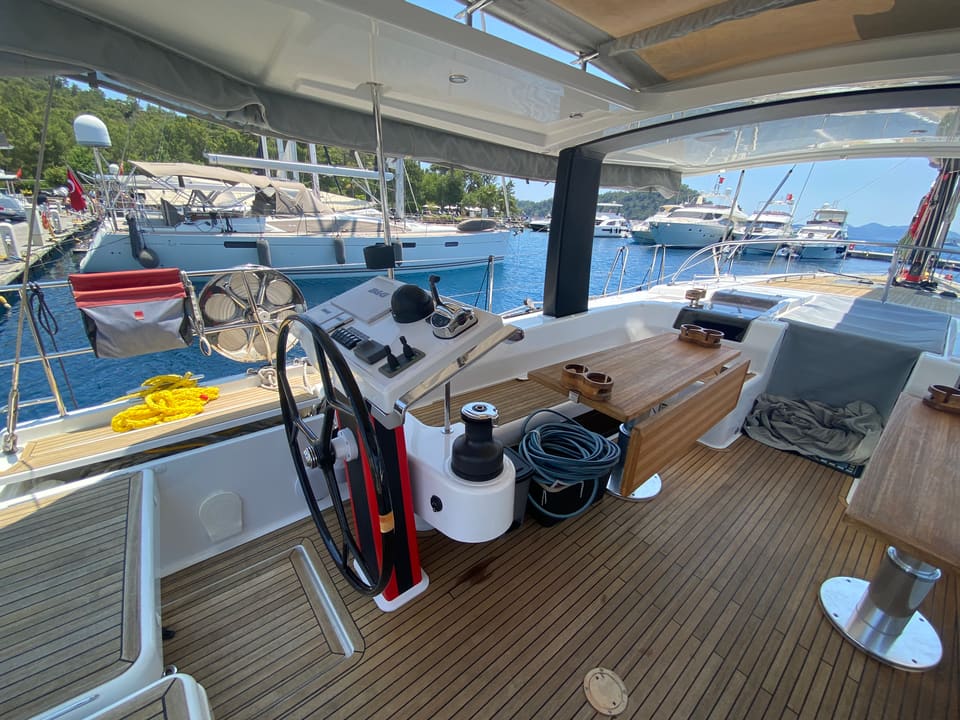 2018 Hanse 548 – cockpit helm station with wheel, instruments, winch and teak cockpit table under bimini
