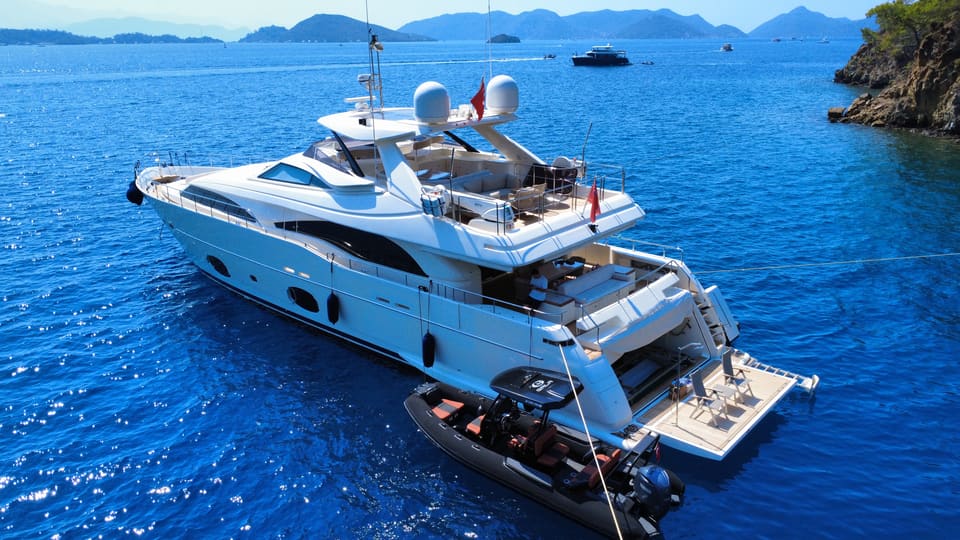 2007 Custom Line 97 – demirdeyken havadan görünüm; flybridge, kıç güverte, açık yüzme platformu ve yanında tender