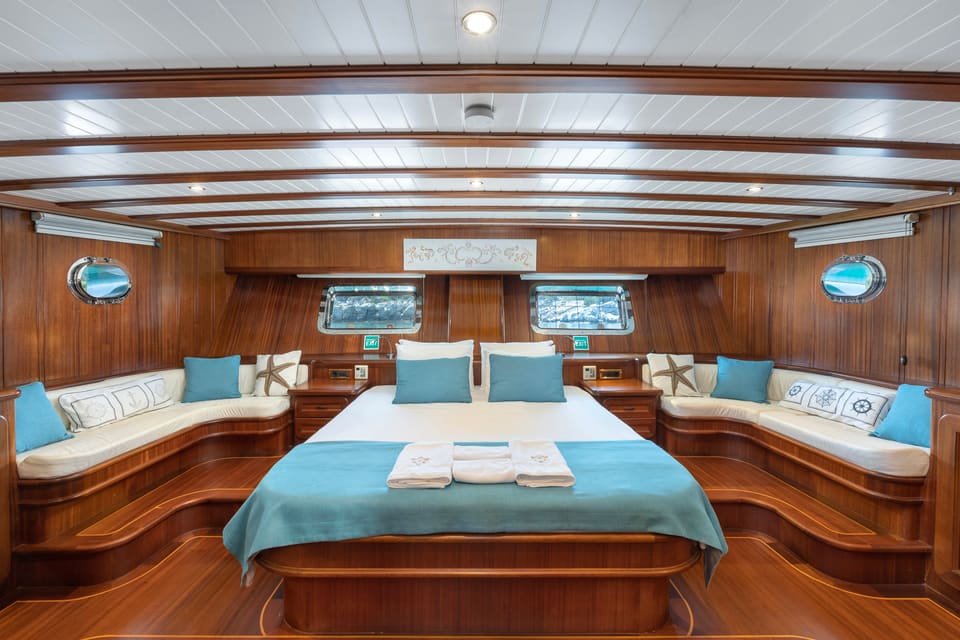 2009 Custom Ketch 31M – full-beam master cabin with central double bed, built-in sofas and warm wood panelling