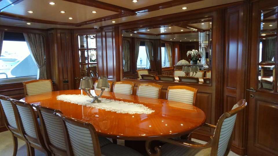 2003 Benetti Classic 115 – formal dining area with glossy oval table, upholstered chairs and rich wood panelling