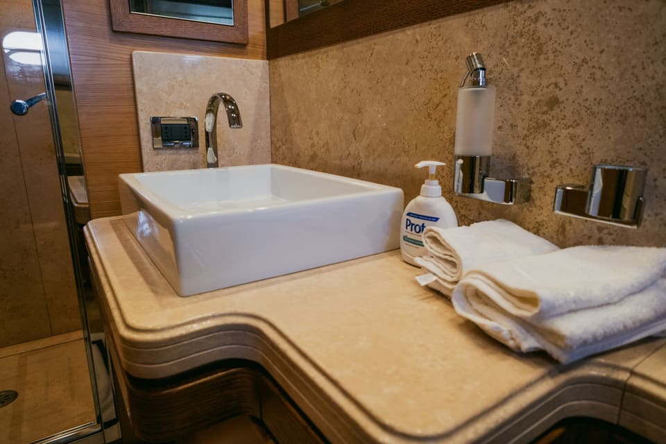 2007 Custom Line 97 – kare tezgah üstü lavabo, krom batarya, mermer tezgah ve temiz havlularla banyo