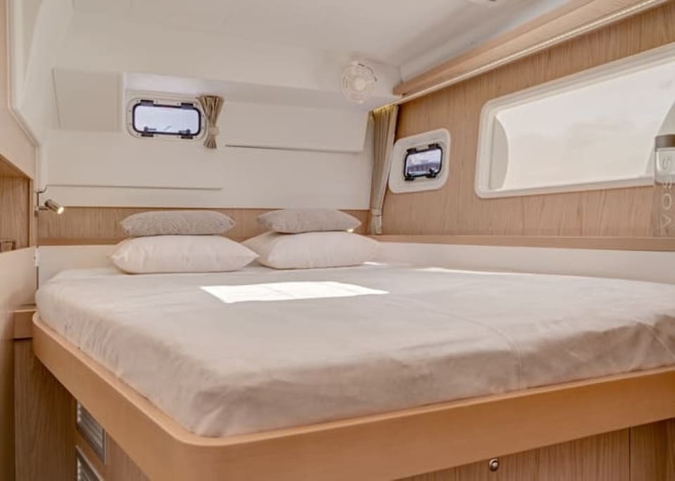2010 Lagoon 400 – cabin with island double bed, hull windows, portholes and warm wood trim