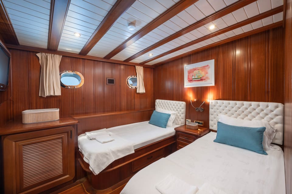 2009 Custom Ketch 31M – twin guest cabin with wood panelling, tufted headboards and portholes