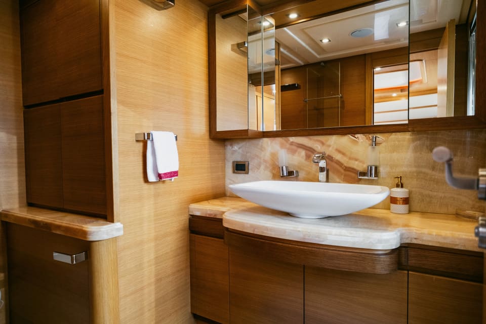 2007 Custom Line 97 – oniks tezgah üzerinde çanak lavabo, ahşap dolap ve aynalı dolaplı banyo