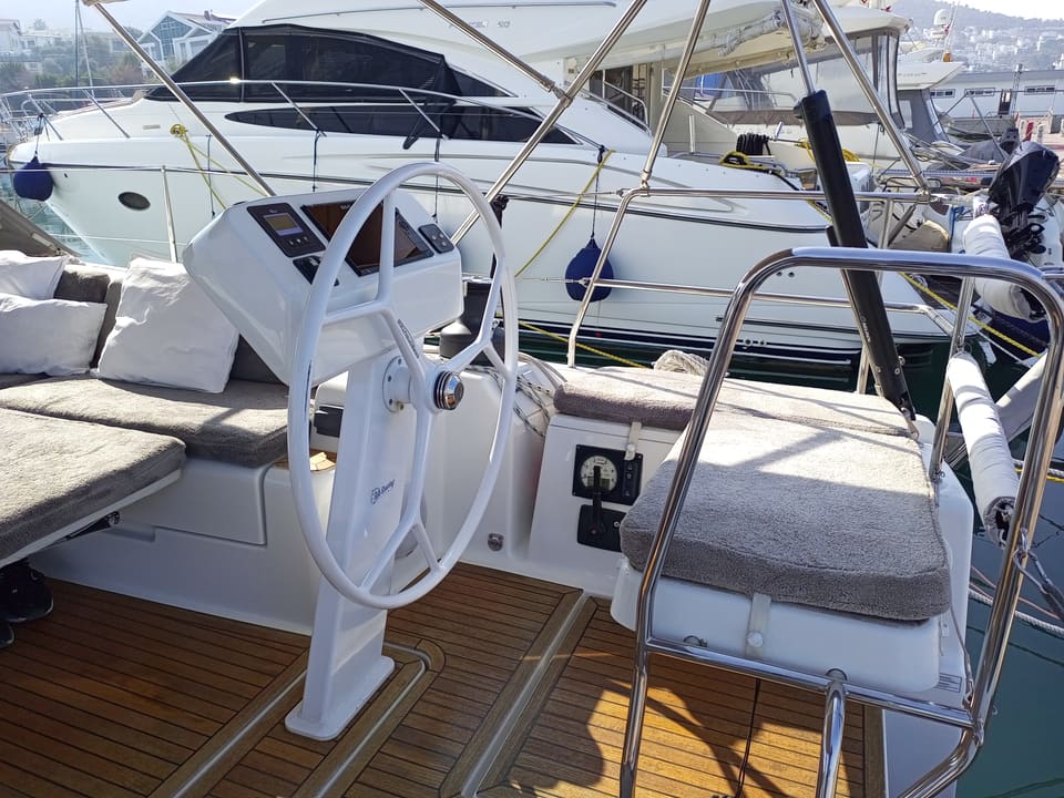 2022 Hanse 508 – helm station with white wheel, instrument console, teak cockpit floor and padded helm seat