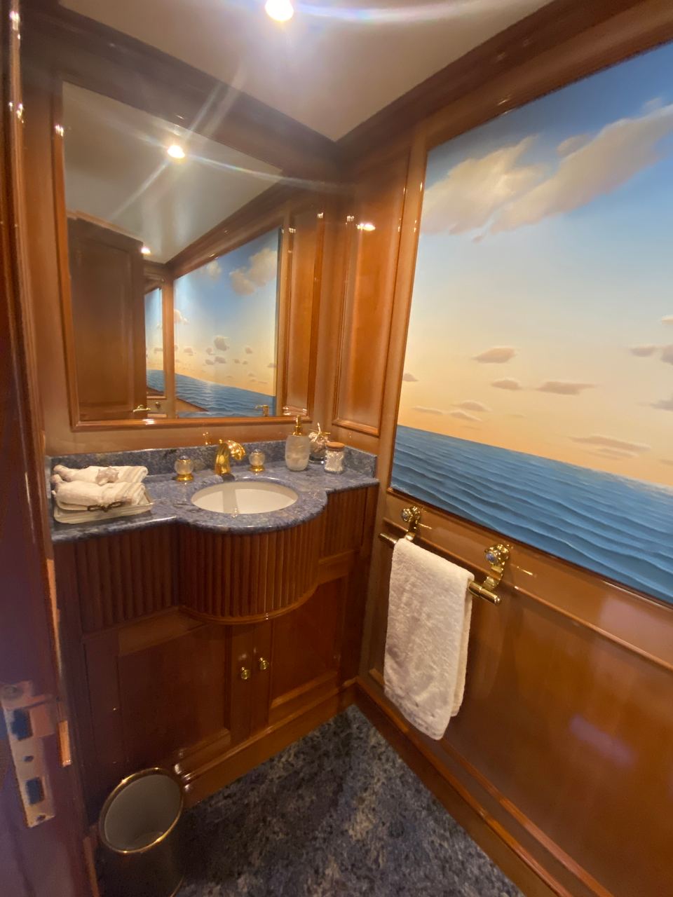 2003 Benetti Classic 115 – bathroom with granite vanity, gold fixtures, wood paneling and sea mural