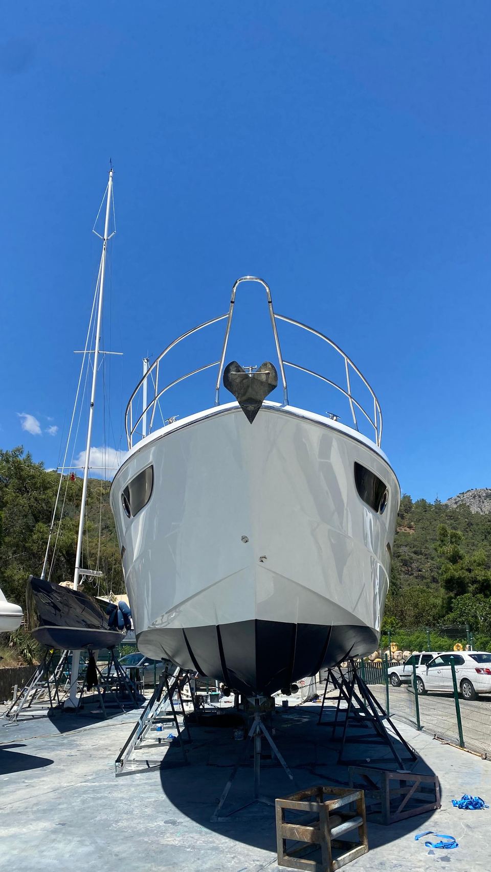 2014 Beneteau Gran Turismo 49 – karada sehpalar üzerinde baştan görünüm, beyaz tekne gövdesi, koyu zehirli boya ve baş vantilatörü
