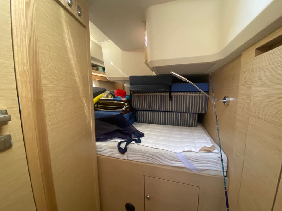 2018 Hanse 548 – guest cabin with single , striped cushions, light oak joinery and reading light