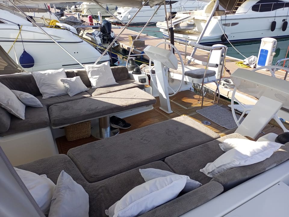 2022 Hanse 508 – gri minderli oturma grupları, masa, çift dümen istasyonu ve tik güverteli kokpit